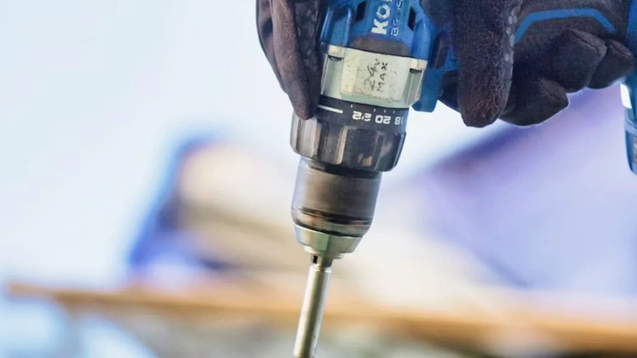 Roofer driving a concealed fastener into a standing-seam metal roof panel